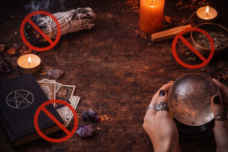 Rituel ésotérique avec bougies, sauge, tarot et cristaux dans une ambiance sombre et mystique