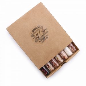 Coffret kraft 7 Days of Self Care Aromatherapy Bath Salts ouvert révélant 7 flacons de sels de bain aux teintes variées — Lumen Arca