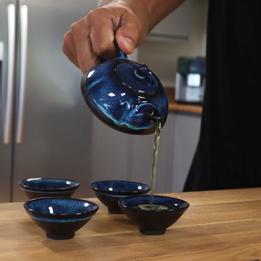 Service à thé en céramique bleu dégradé, théière versant dans les tasses assorties - Lumen Arca