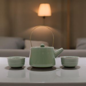 Service à thé vert jade avec anse dorée, théière et tasses sur table